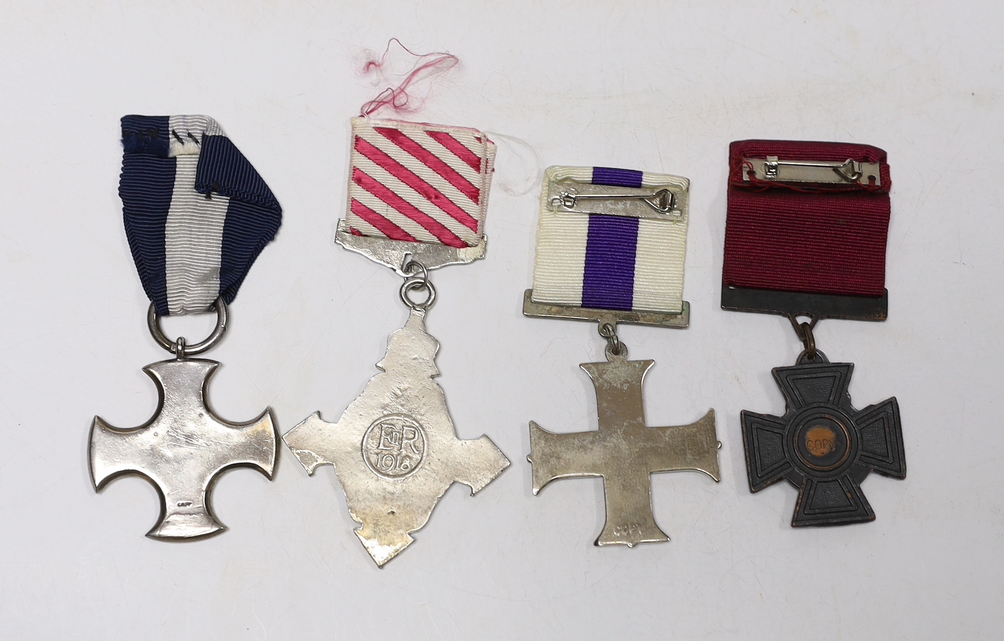 Four well produced replica medals. A Victoria Cross, a Distinguished Service Cross, a Military Cross and an Air Force Cross